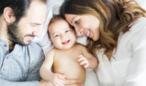 bébé souriant au milieu de ses parents